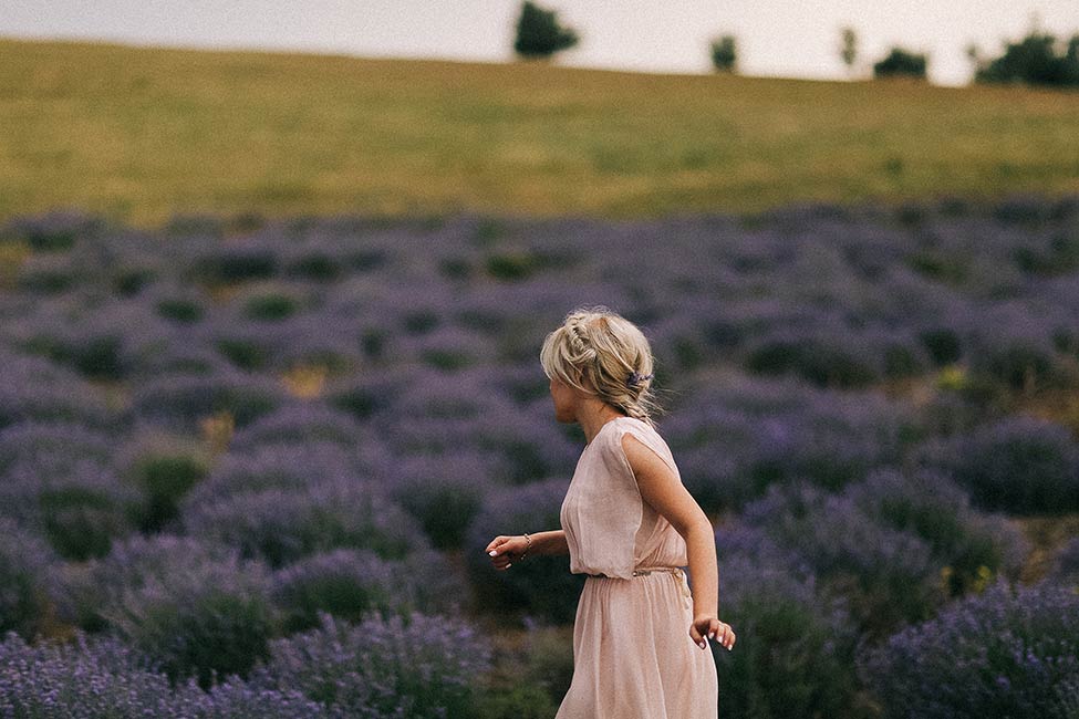 A bride walks in French lavender field in the Luberon for wedding photography.