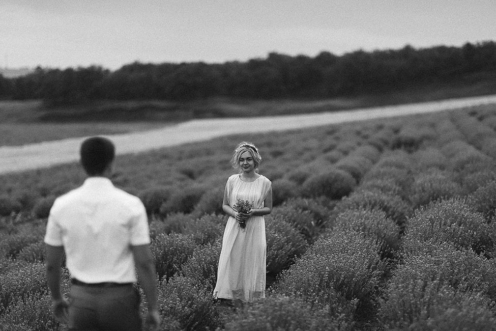 A bride waiting for her groom in a field with a lavender bouquet in the south of France.