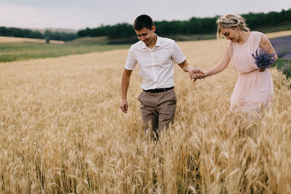 A couple walks through fields of wheat in Cobusca Noua, MD on their wedding day adventure.