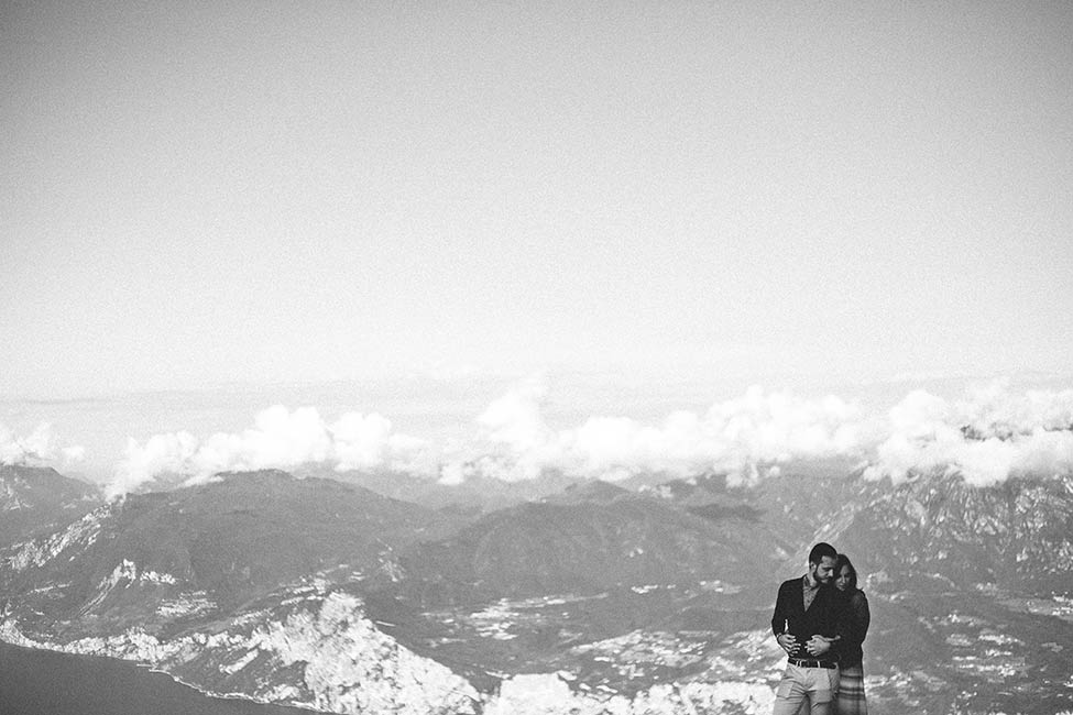 Enrico and Eleonora embrace above the clouds, during their engagement session on monte baldo.