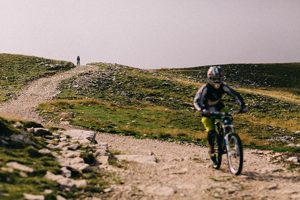 Mountain biker photobombs adventurous couples engagement photos.